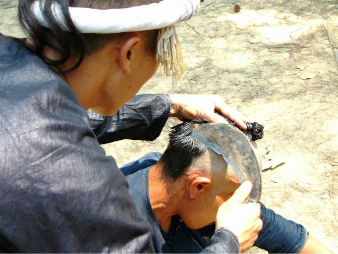 Haircut with a reaphook of Basha minority nationality in Guizhou province.